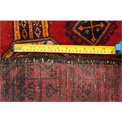 Persian Baluchi crimson ground rug, decorated with three columns of geomtric motifs