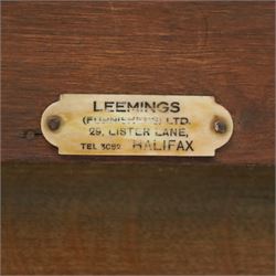 Leemings of Halifax (est. 1872) - Arts & Crafts oak side table, rectangular caddy top with raised moulded back, the frieze carved with central Yorkshire rose motif flanked by two drawers, raised on twin stylised lyre end supports formed of C-scrolls, united by shaped stretcher