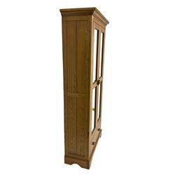 Tall oak display cabinet, projecting cavetto cornice over two glazed doors and single drawer, on bracket feet