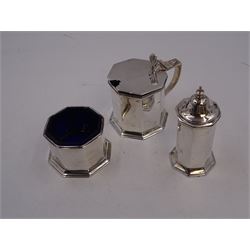 1920s silver three piece cruet set, comprising mustard pot and cover, pepper and open salt, each of faceted octagonal form, the mustard pot with pierced thumbpiece and capped handle, hallmarked Stokes & Ireland Ltd, Chester 1923 & 1924, max height 8.5cm, mustard and salt with original blue glass liners