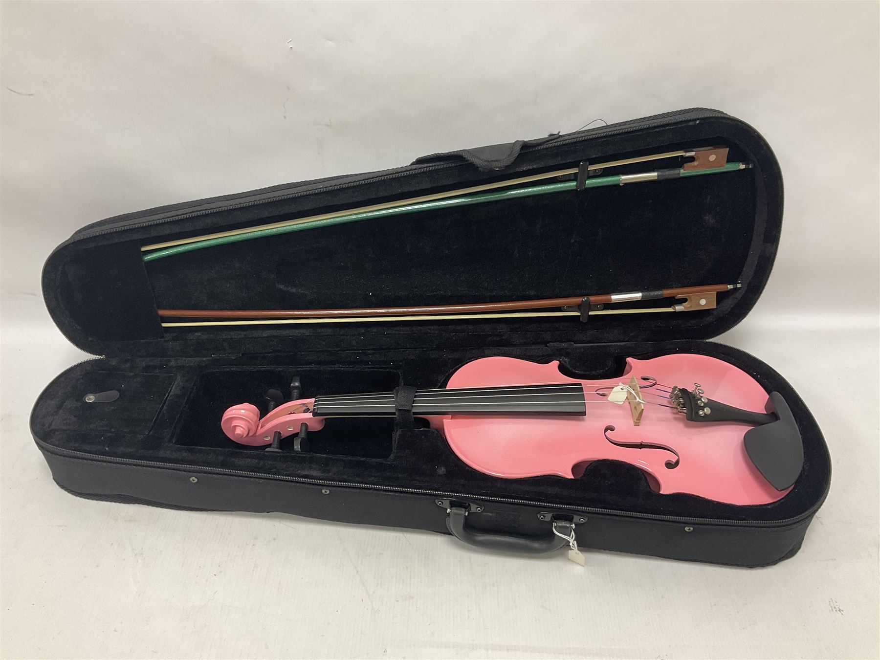 Zest full size pink violin, with a solid wood body and maple head, with matching pink bow and two further bows, in a hard case Length 60cm