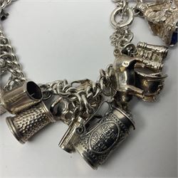 Silver charm bracelet, with twenty eight charms, including typewriter, rocking chair, carriage, cauldron, etc