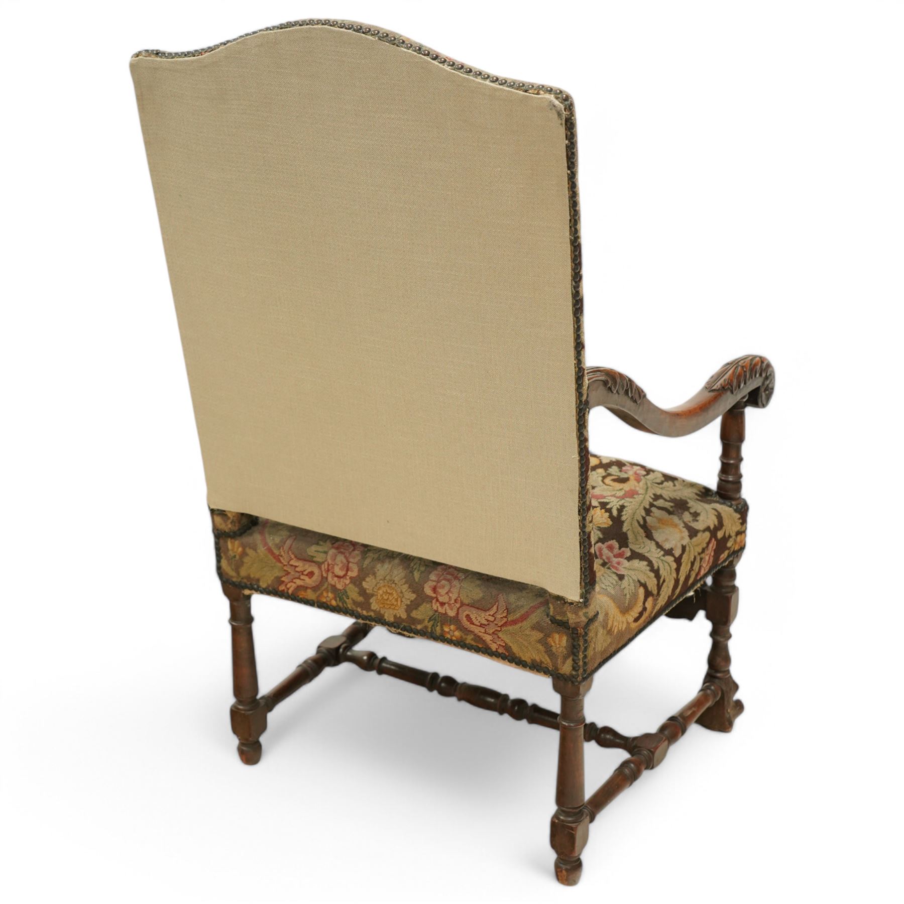Baroque design walnut framed open armchair, arched cresting rail over acanthus carved shaped arms with scrolled terminals, upholstered in floral pattern fabric with stud bands, shaped and pierced middle rail carved with curled acanthus leaves and flower heads, on turned and block front supports terminating to paw feet, united by turned stretchers 