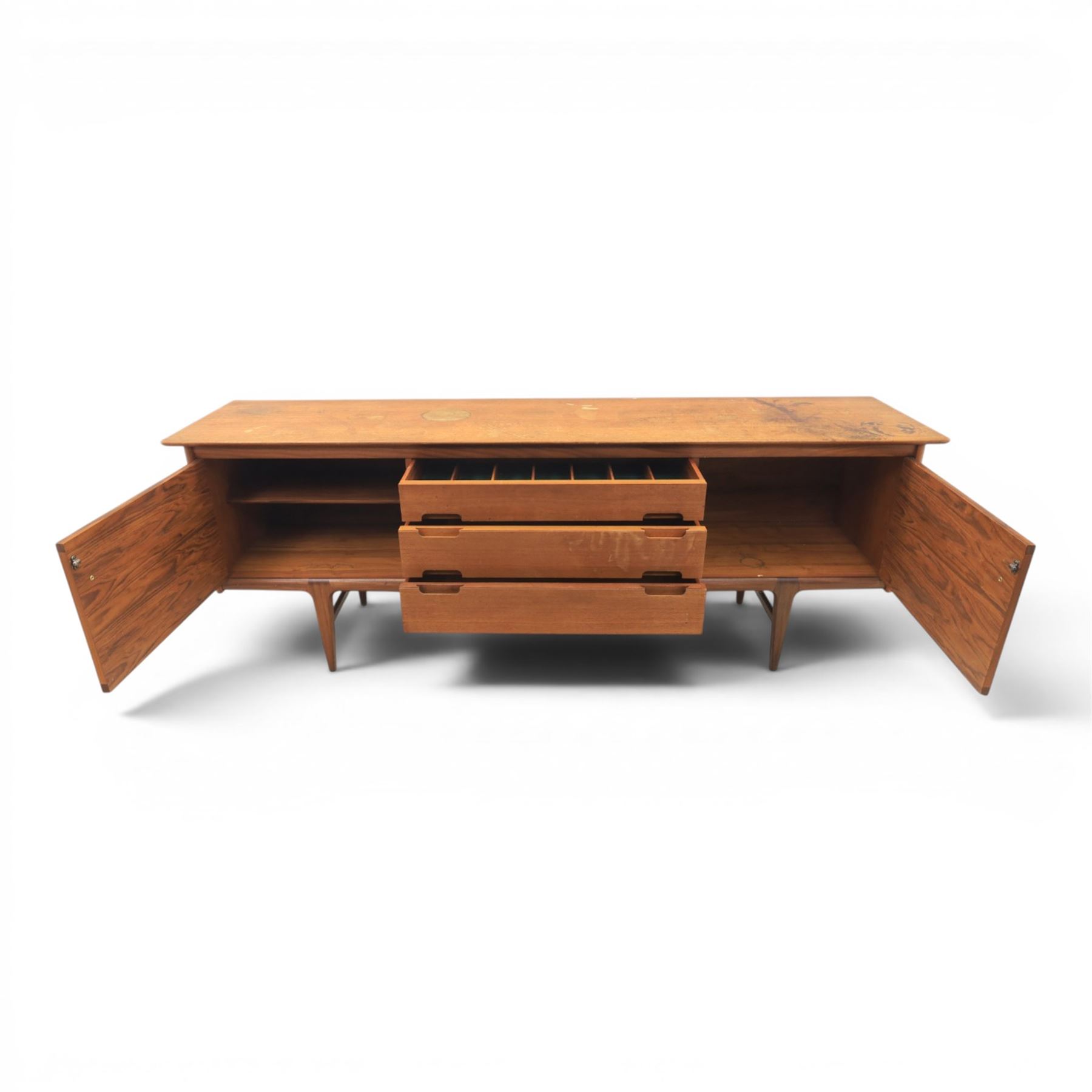 John Herbert for Youngers - 'Fonseca' mid-century teak sideboard, rectangular top above a central bank of three drawers one fitted for cutlery, flanked by cupboards with fixed shelved interior, raised on tapering supports 