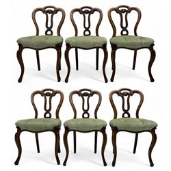 Set of six carved Victorian walnut balloon back dining chairs, button upholstered in green velvet fabric, back with foliate carved decoration supported on scroll form legs 