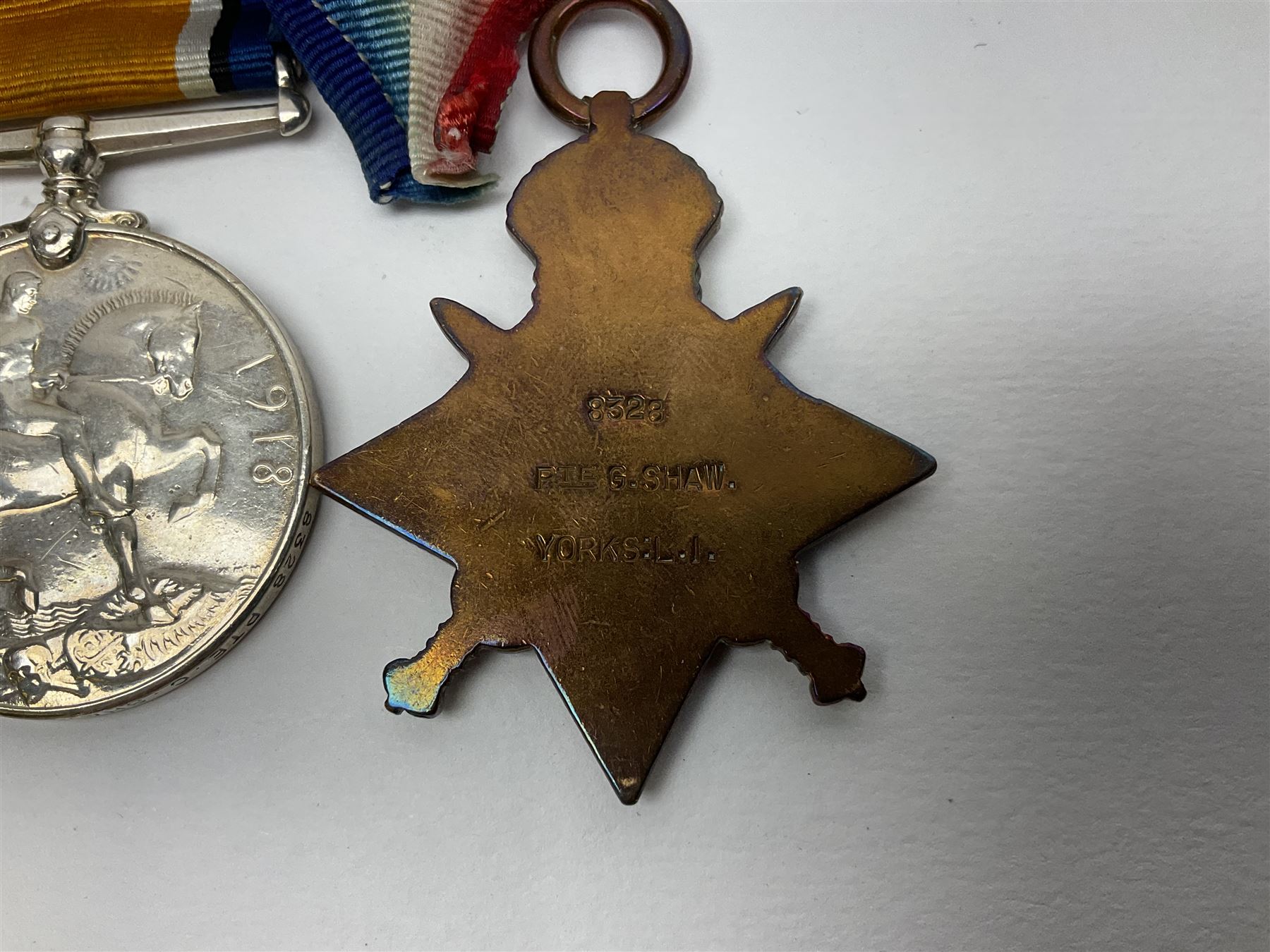 WW1 group of three medals comprising British War Medal, Victory Medal and 1914 Star awarded to 8328 Pte. G. Shaw Yorks: L.I.; on hanging bar with WW2 1939-1945 War Medal and WW1 ribbon bar with rosette to 1914 Star ; all with ribbons; and WW2 1939-1945 War Medal with ribbon