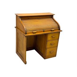 Leeway - late 19th century light oak child's roll-top desk, tambour top opening to reveal fitted interior with green felt writing surface and five pigeonholes, over three graduated drawers on the right side, raised on panelled side supports
