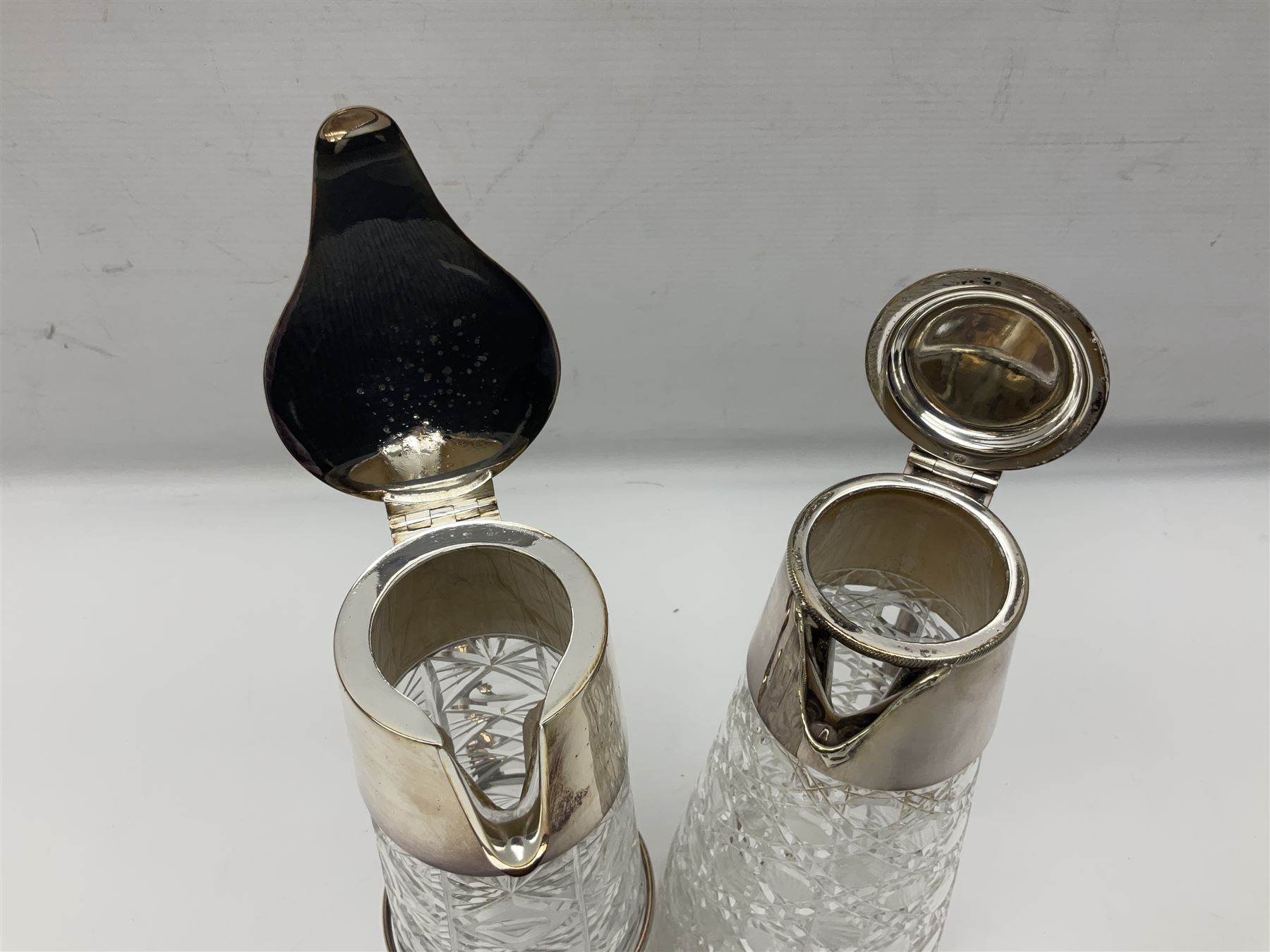 Pair of Mappin and Webb silver plate pierced pedestal bon bon dishes, together with other silver plate comprising teapot stand engraved with lion's head to centre, two cut glass claret jugs, two bottle coasters with acorn decoration, two open salts upon dolphin mounts, tea caddy, three piece cruet set and a large oval tray with pierced sides and upon four ball feet