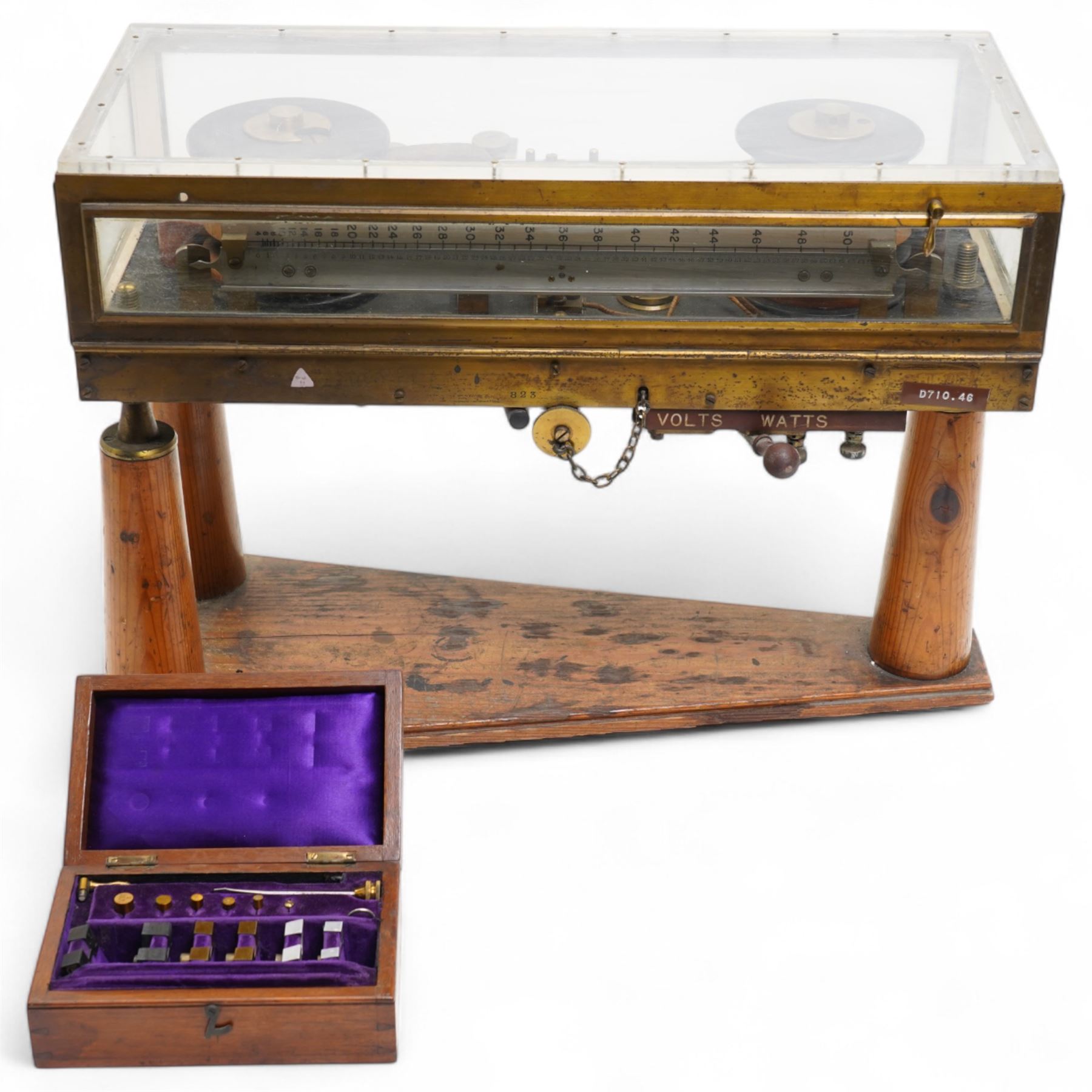 Lord Kelvins Patent electric current balance, no. 823, by Kelvin & James White Ltd Glasgow & London, with two pairs of horizontally mounted coils, suspended beam balance mounted on an ebonite base under glass and brass cover, with box of weights and accessories, raised on three wooden supports, W51cm H37.5cm