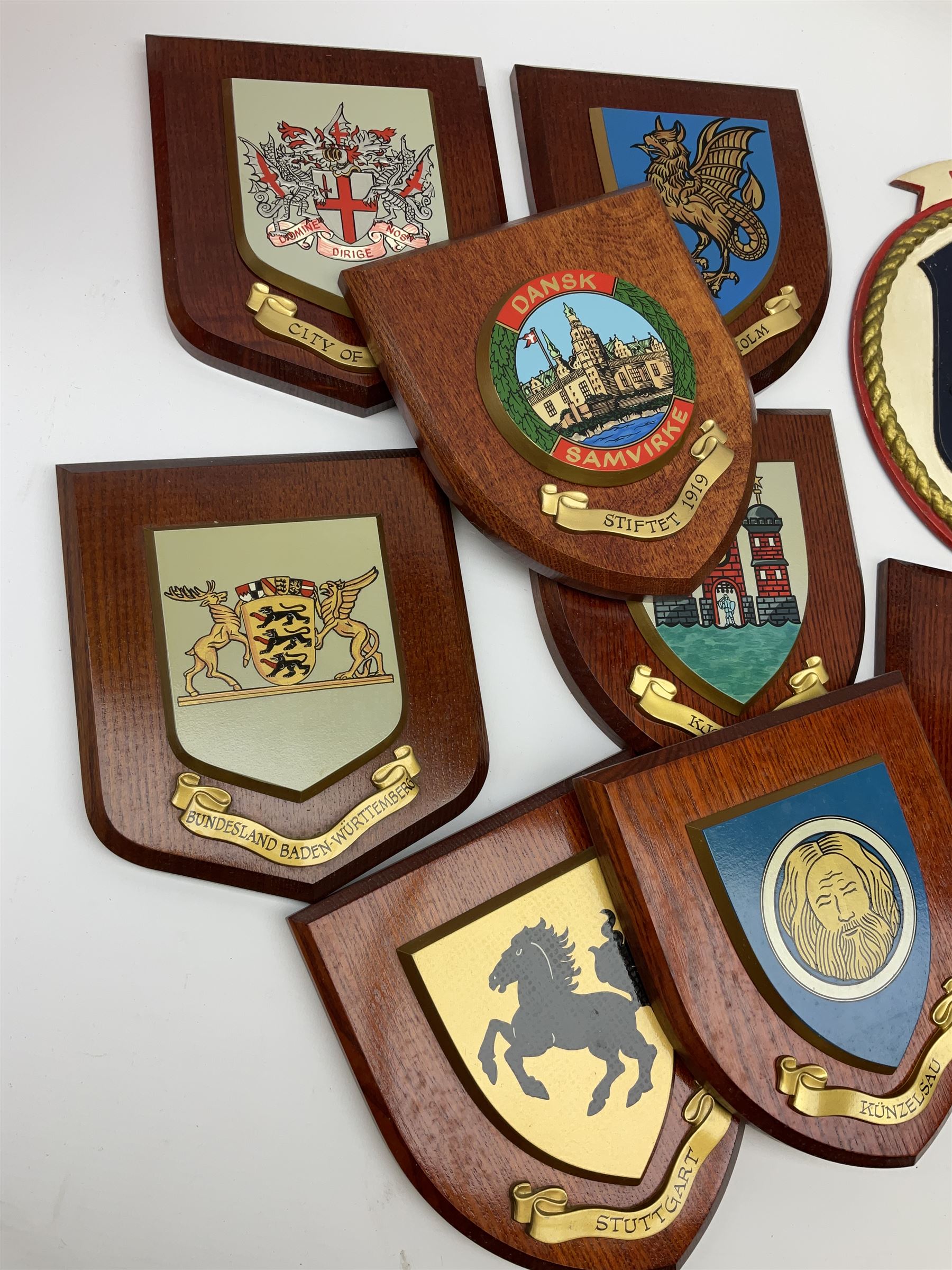 Various European cities and states, wooden heraldic shields each with hand painted raised shield including Baden Wurttemberg, Kunzelsau, City of London, Kingston upon hull etc, seventeen in total. . 