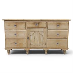 Victorian waxed pine farmhouse dresser, featuring seven drawers with central cupboard, moulded glass handles, raised on turned feet