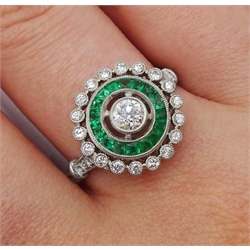Platinum round diamond and calibre cut emerald target design ring, with diamond set shoulders
