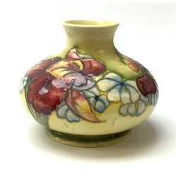 A Moorcroft vase, circa 1950, of squat bulbous form, decorated in the Orchid pattern upon a yellow glazed ground, with impressed and blue painted WM initials for Walter Moorcroft, H10.5cm. 