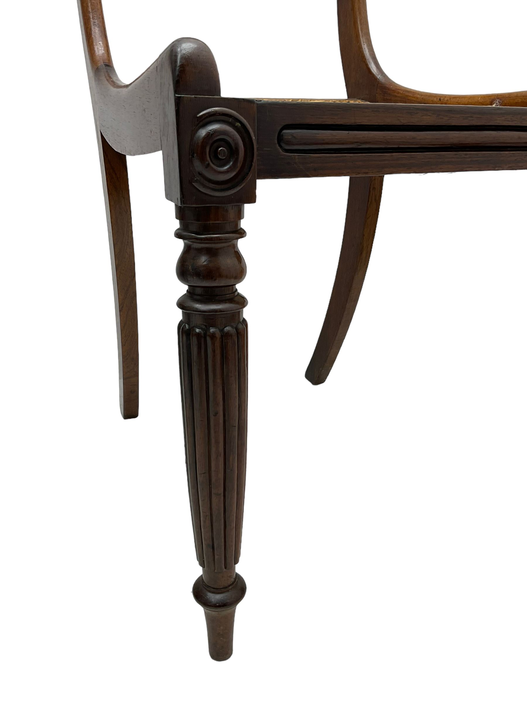 Pair of Regency rosewood framed side chairs, carved back rails over cane seat, raised on reeded supports (W46cm D50cm H84cm); set of three Edwardian walnut cane seat bedroom chairs, carved shield back (W41cm H88cm)