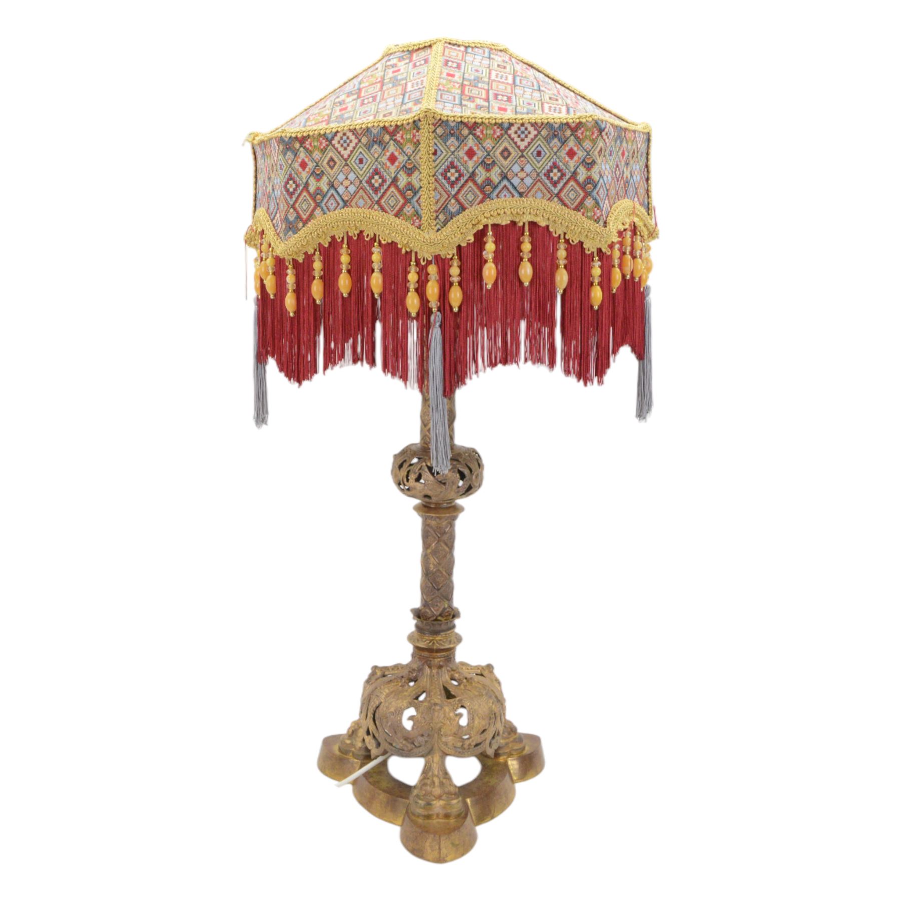 Gilt table lamp, three lion paw feet on a triangular base with column central support decorated with floral motifs, with octagonal shade, H85cm 