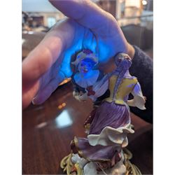 Mid 18th century Meissen figure group, The Tyrolean Dancers, circa 1740, modelled as two swirling figures with their arms linked, he in yellow hat with red rosette, blue jacket, red breeches with red rosette, and yellow shoes with green rosette, she in white blouse with red ribbons, yellow and red bodice, white apron over puce skirt and yellow shoes with green rosettes, her hair fashioned into two plaits secured by red ribbon, upon a shaped mound base, within a scrolling gilt metal mount, with blue crossed swords mark to base, overall H19cm
