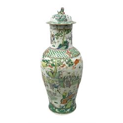 Chinese Famille Verte covered vase of baluster form, with  elongated cylindrical neck, painted with figures in a variety of poses, with foo dog decoration on cover, H64cm