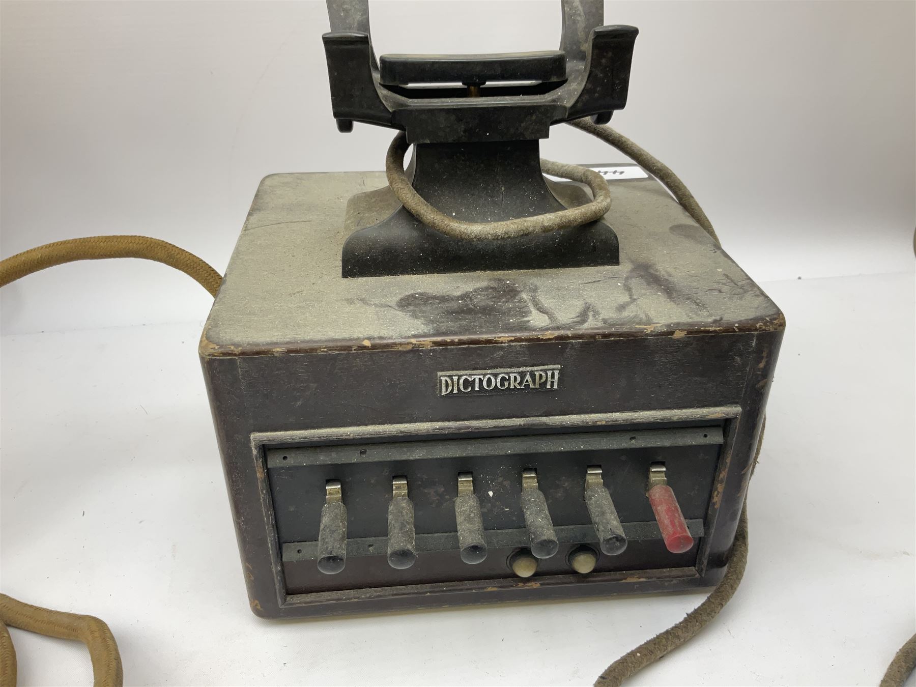 Early-mid 20th century internal telephone system, comprising exchange box with attached TMC rotary telephone and dictograph with Bakelite handset and support upon stained wood case, and 1960s black Bakelite telephone model 312L with G.P.O sticker beneath, largest H30.5cm W36.5cm D30cm