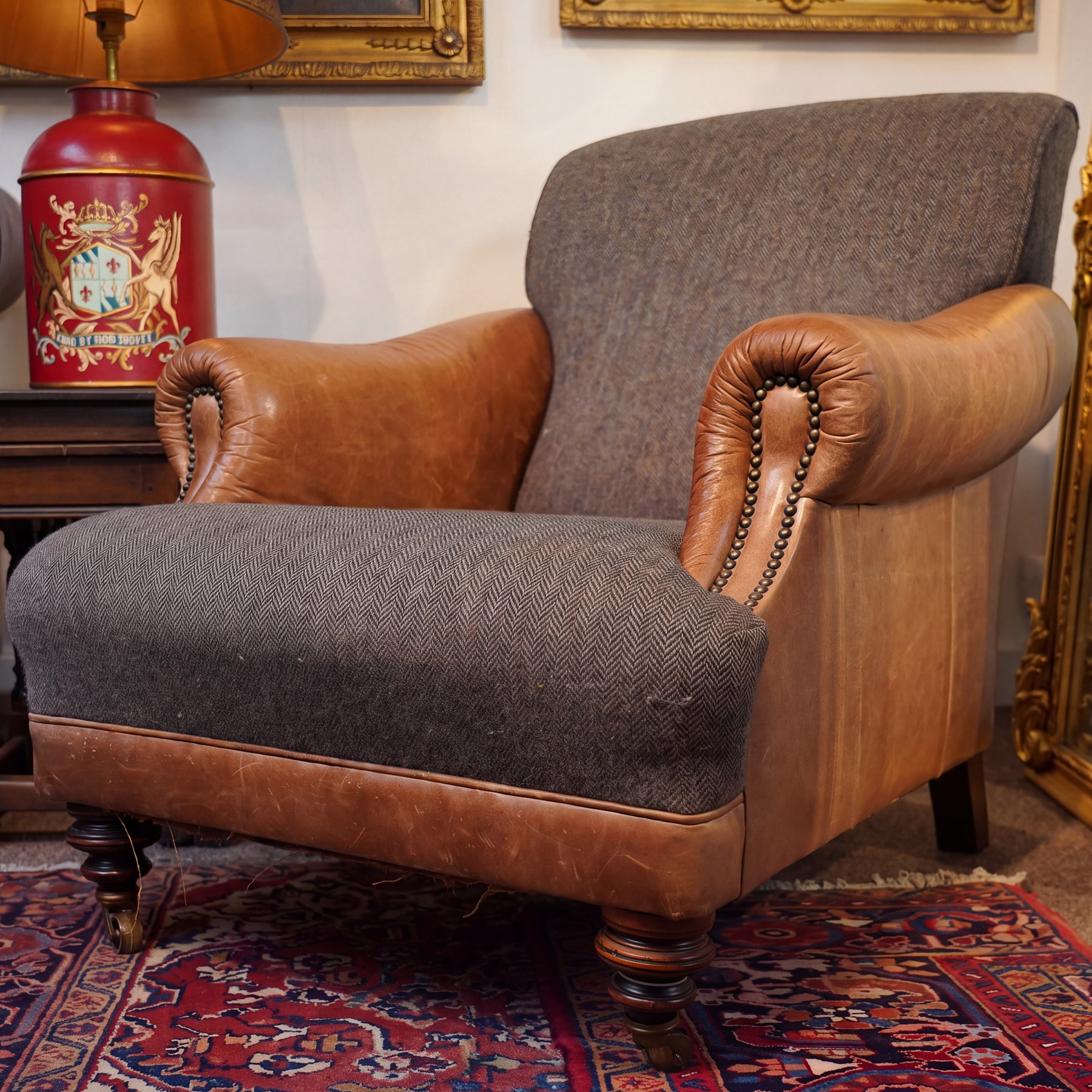 Tetrad - 'Taransay' Harris Tweed and tan leather club armchair, Howard shape with reclined back over deep seat and rolled arms with studwork, raised on turned front supports with castors, the sides and arms upholstered in tan leather with seat and back in herringbone-stitched Harris Tweed