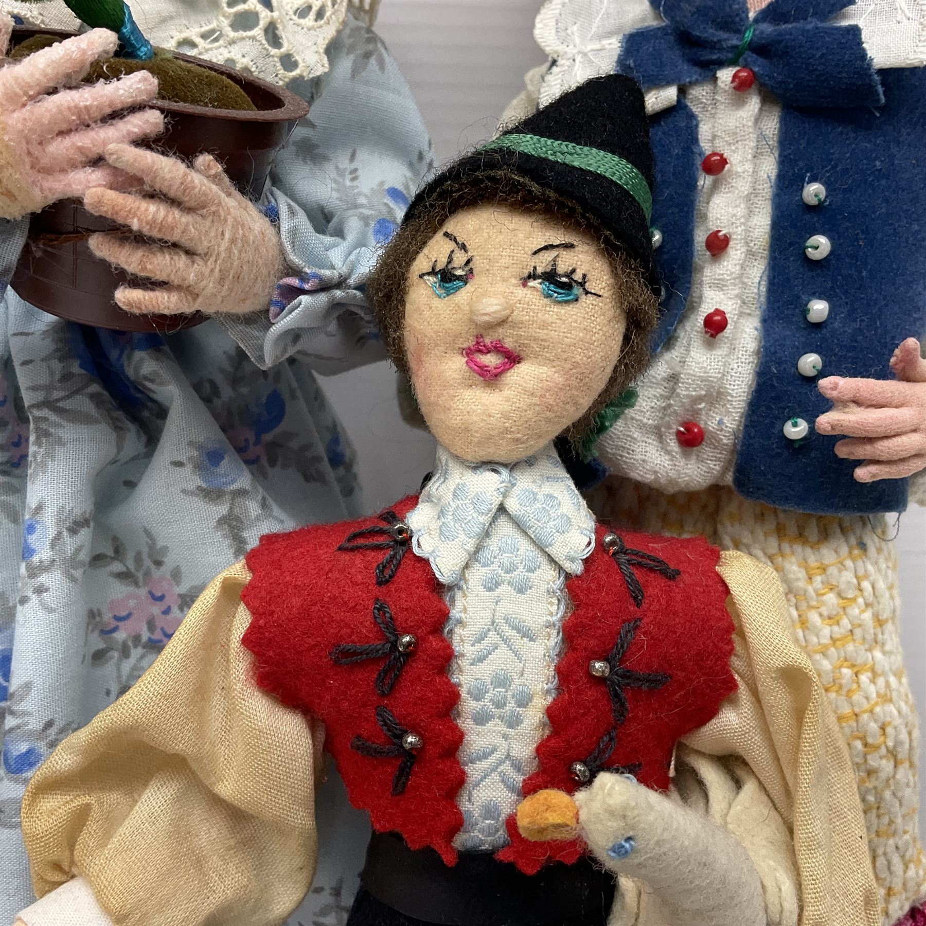 Anna Meszaros Hungary - five hand made needlework figurines including goose girl with stick H20cm; shepherdess in a sitting pose playing a penny whistle with a lamb on her knee; young girl holding a flowerpot; and two others (5)  Auctioneer's Note: Anna Meszaros came to England from her native Hungary in 1959 to marry an English businessman she met while demonstrating her art at the 1958 Brussels Exhibition. Shortly before she left for England she was awarded the title of Folk Artist Master by the Hungarian Government. Anna was a gifted painter of mainly portraits and sculptress before starting to make her figurines which are completely hand made and unique, each with a character and expression of its own. The hands, feet and face are sculptured by layering the material and pulling the features into place with needle and thread. She died in Hull in 1998.