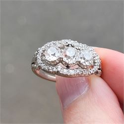 Late 19th / early 20th century platinum diamond ring, three old cut diamonds, in an openwork setting surrounded by further old cut diamonds, with pierced design shoulders, principal three diamonds total weight approx 1.45 carat, in a velvet and silk lined box by Selfridges