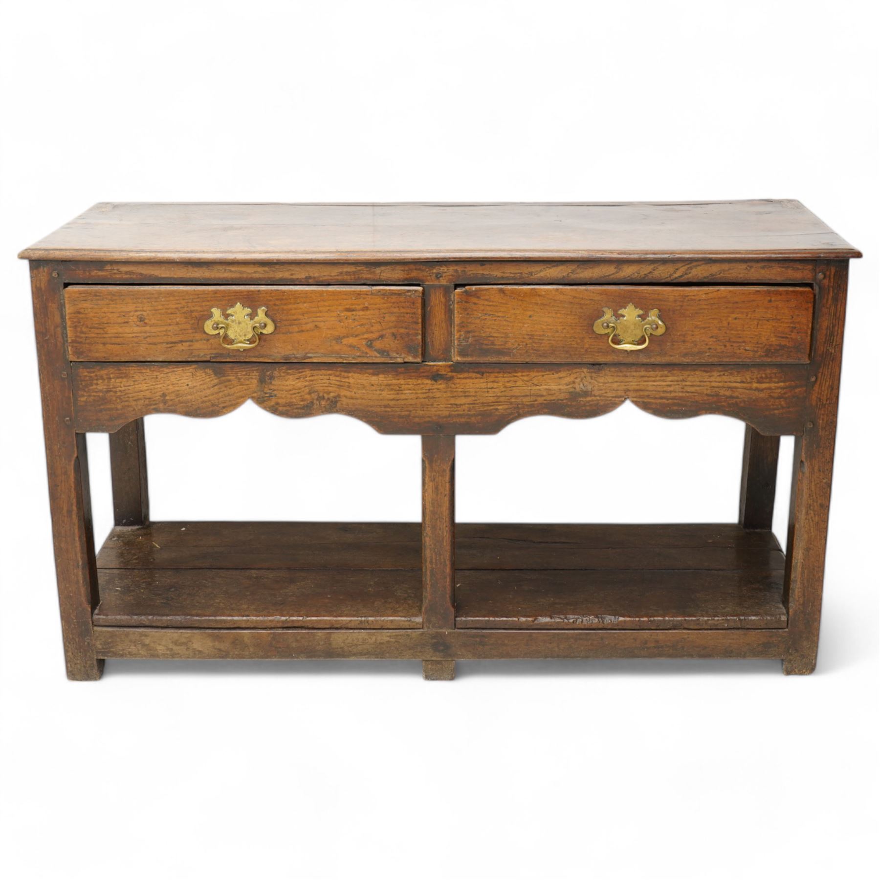 18th century oak dresser base, moulded rectangular top over two drawers and shaped apron, moulded drawer fronts fitted with shaped brass handle plates and swan neck handles, on chamfered square supports united by pot board base 