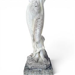 Weathered cast stone garden statue of a 'Shy Maiden', raised on square plinth base