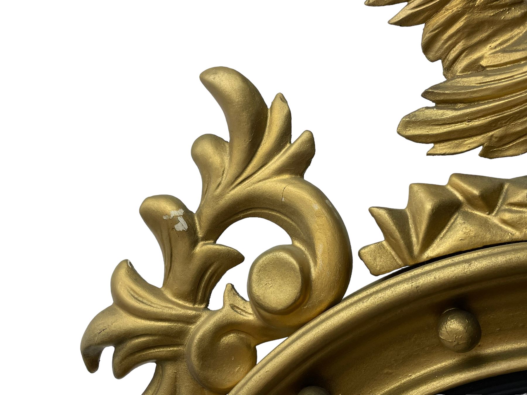 Pair of Regency period giltwood convex wall mirrors, moulded circular frame decorated with spherical mounts surmounted by a carved eagle with spread wings, foliage scroll carved upper and lower brackets, reed moulded and ebonised slip enclosed convex mirror plate 