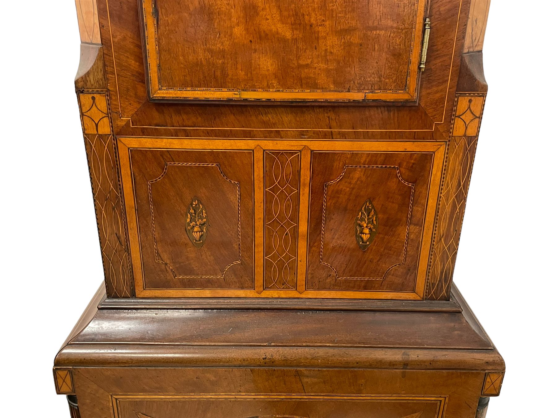 John Stonehouse of Leeds - mahogany 8-day longcase clock with a painted oval dial c1830, hood with a swans necked pediment and profuse contrasting inlay to both the hood and case, oval hood door with flanking pilasters and Corinthian capitals, conforming case with canted corners and short triple spire door, broad plinth with matching inlay and canted corners on shallow base, dial depicting masonic regalia, symbols, and pictorial depictions of the humanities, faith, hope, charity and righteousness, black chapter with white roman Arabic’s, date recorder and matching “crown” hands, dial pinned to a rack striking movement with a recoil anchor escapement, striking the hours on a coiled underslung gong. With weights and gridiron pendulum. 
This clock case is of large, impressive dimensions and was almost certainly commissioned for a large masonic lodge in Leeds, a rare and unique example.