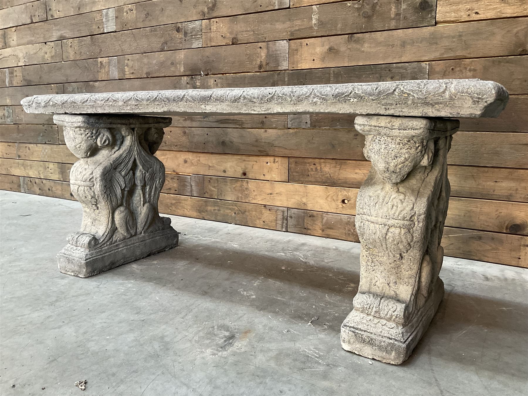 Cast stone garden Rams Head bench, two pillars set with architectural rams heads, rectangular slab seat