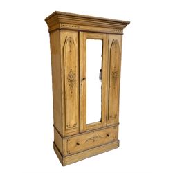 19th century painted pine wardrobe, the projecting cornice over mirror glazed door, with painted decoration depicting scrolling foliate and urns, drawer to base on skirt