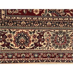 Royal Kashmir worsted wool modern Persian design area rug, with crimson field and stylised rosette patterning throughout, surrounded by wide multi-band border incorporating cartouche and lotus flower motifs
