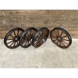 Set of four wheels from an early 20th century cart, wood with metal outer