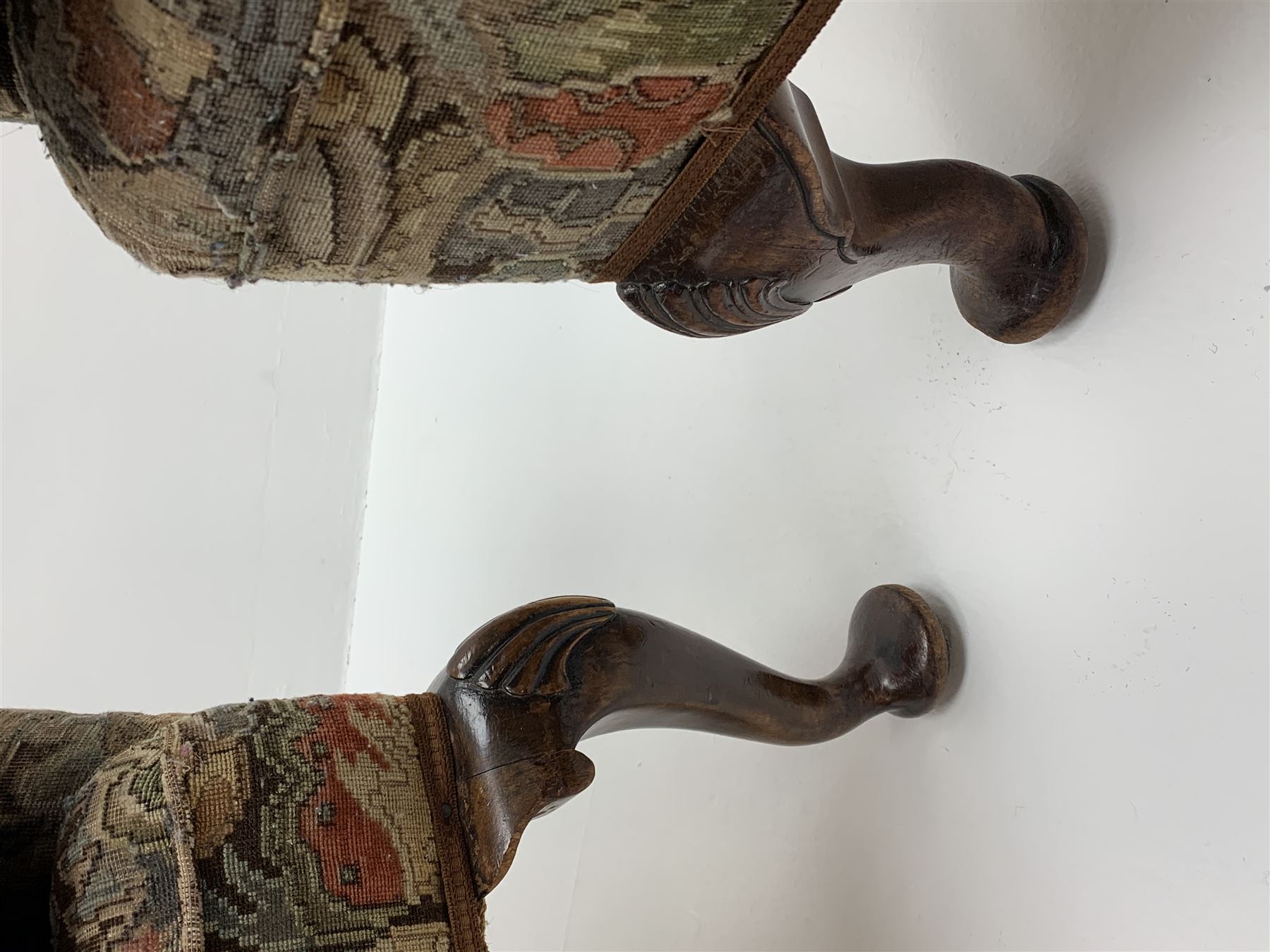 Matched pair early 20th century Queen Anne style wingback armchairs, walnut framed, sprung seats with seat cushions upholstered in needle work cover, shell carved cabriole front feet