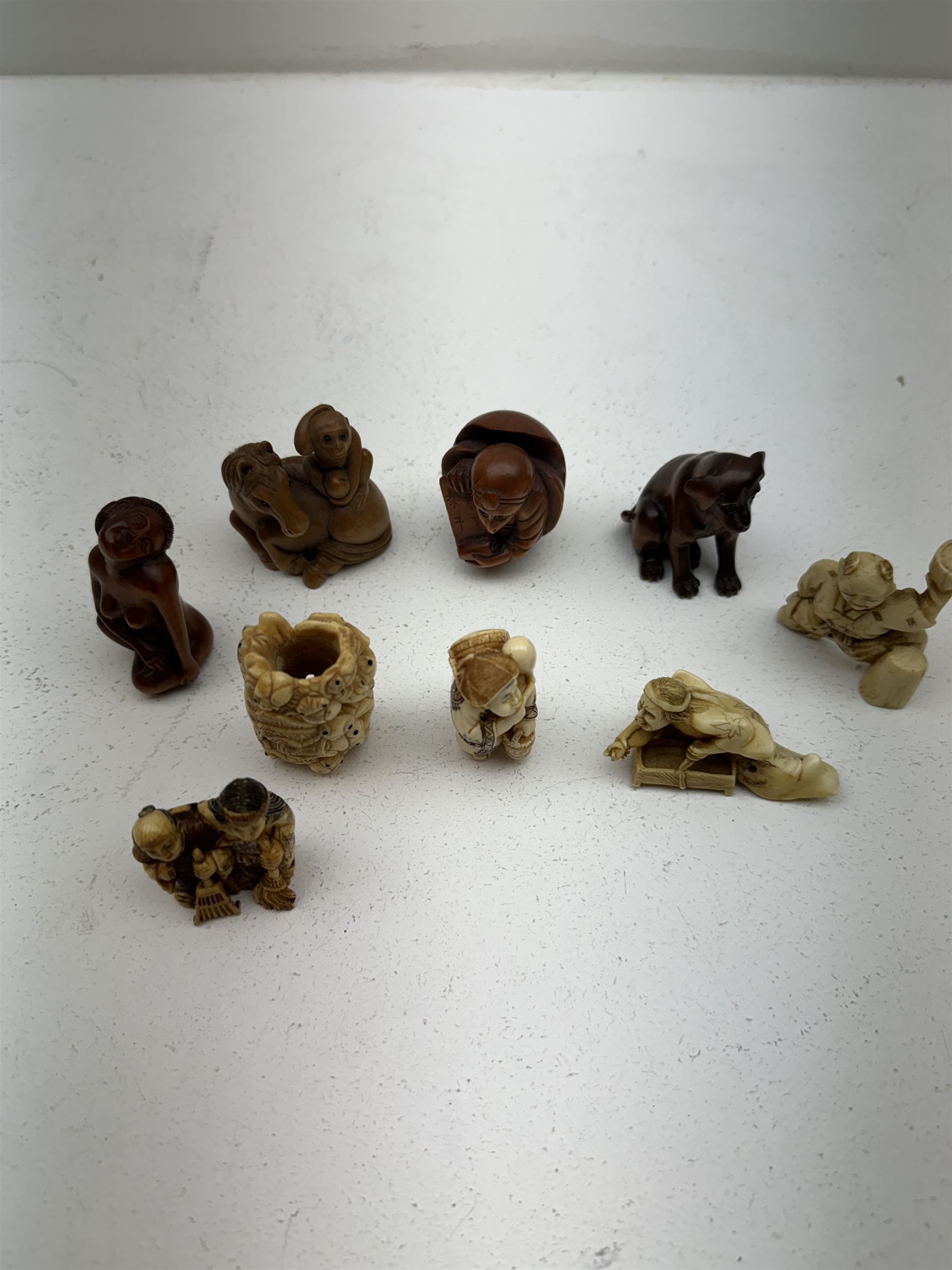 Nine wooden and composite carved netsukes, to include dog, horse and monkey, female figure etc 