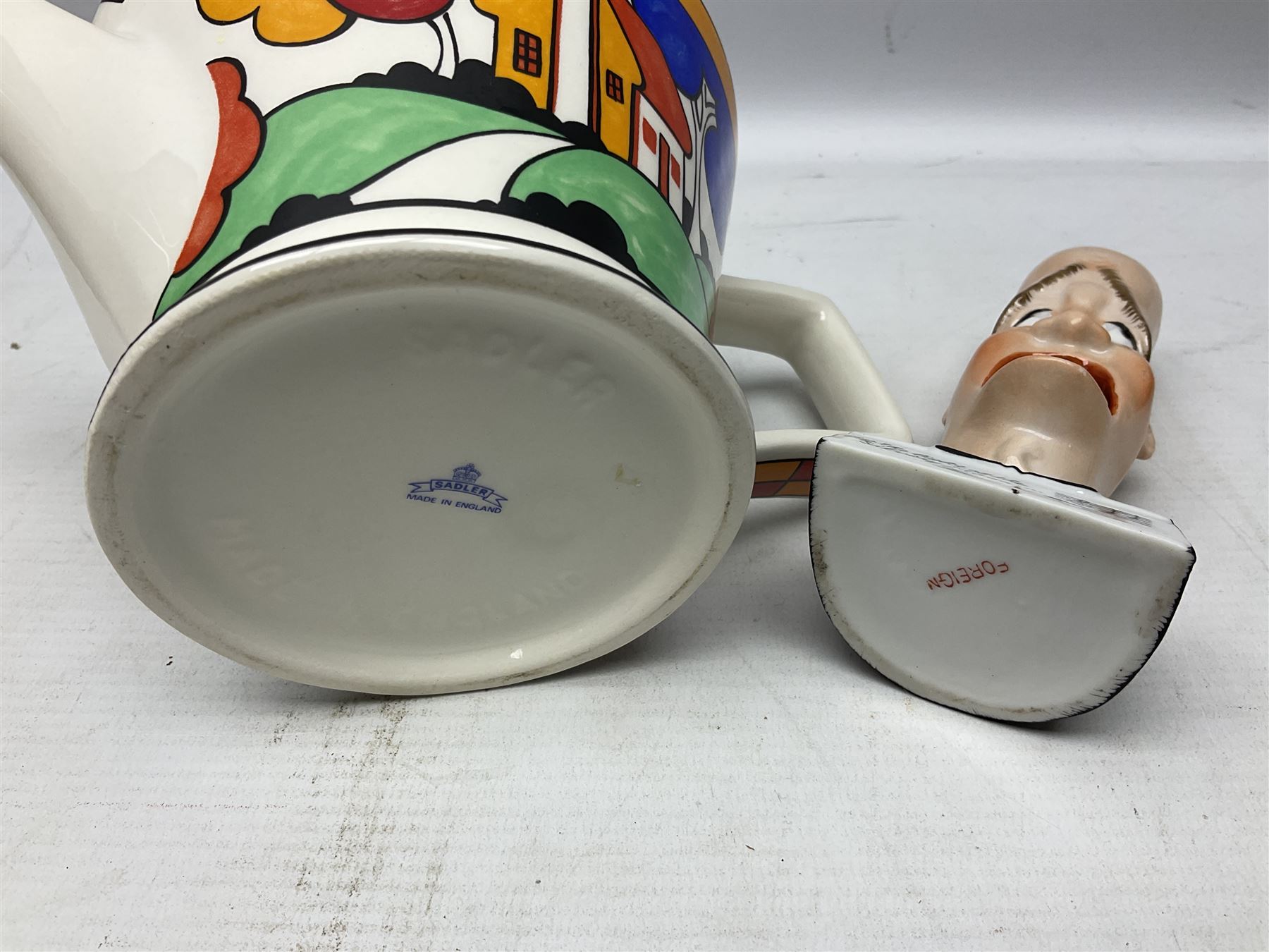 Novelty ashtray modelled as bald headed singer, the base entitled `By the light of the silvery moon...' together with a Sadler teapot of Clarice Cliff Farmhouse pattern style