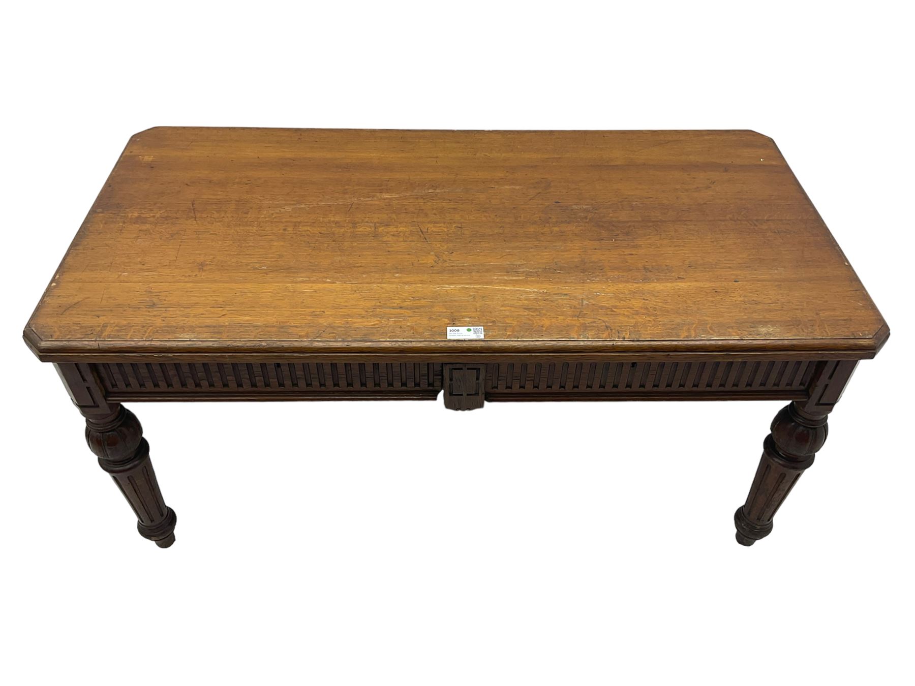Late 19th century oak library table, moulded rectangular top with canted corners, fitted with two frieze drawers with fluted facias, on lobe carved and fluted turned supports 