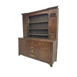 George III oak dresser, projecting cornice over three tier plate rack flanked by reeded uprights and two cupboards, enclosed by slatted and panelled doors above small drawers, the lower section fitted with six drawers and two cupboards, on bracket feet