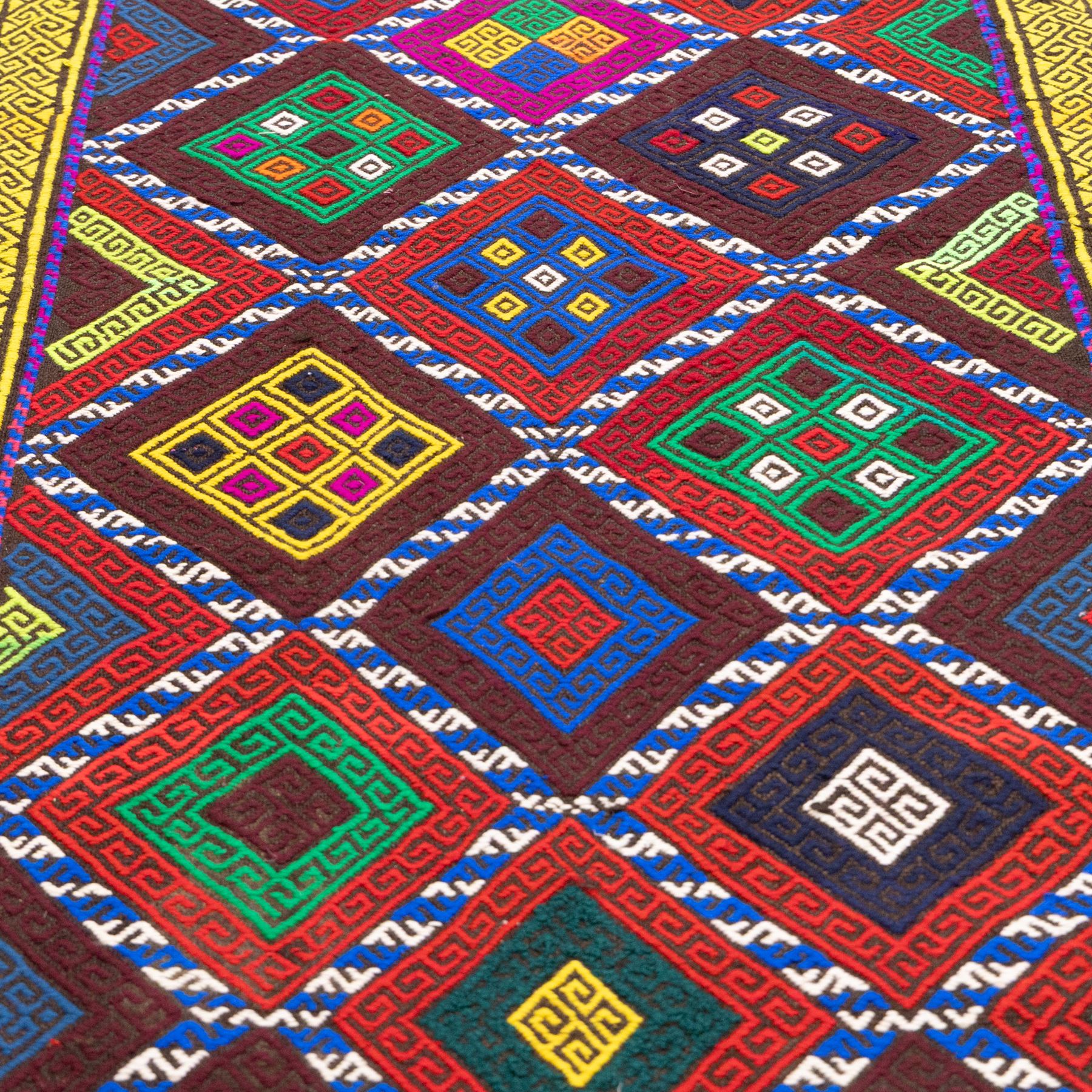 Central Asian Suzani kilim flatweave runner, decorated with a repeating diamond lattice enclosing polychrome geometric motifs within yellow key fret borders, fringe ends 