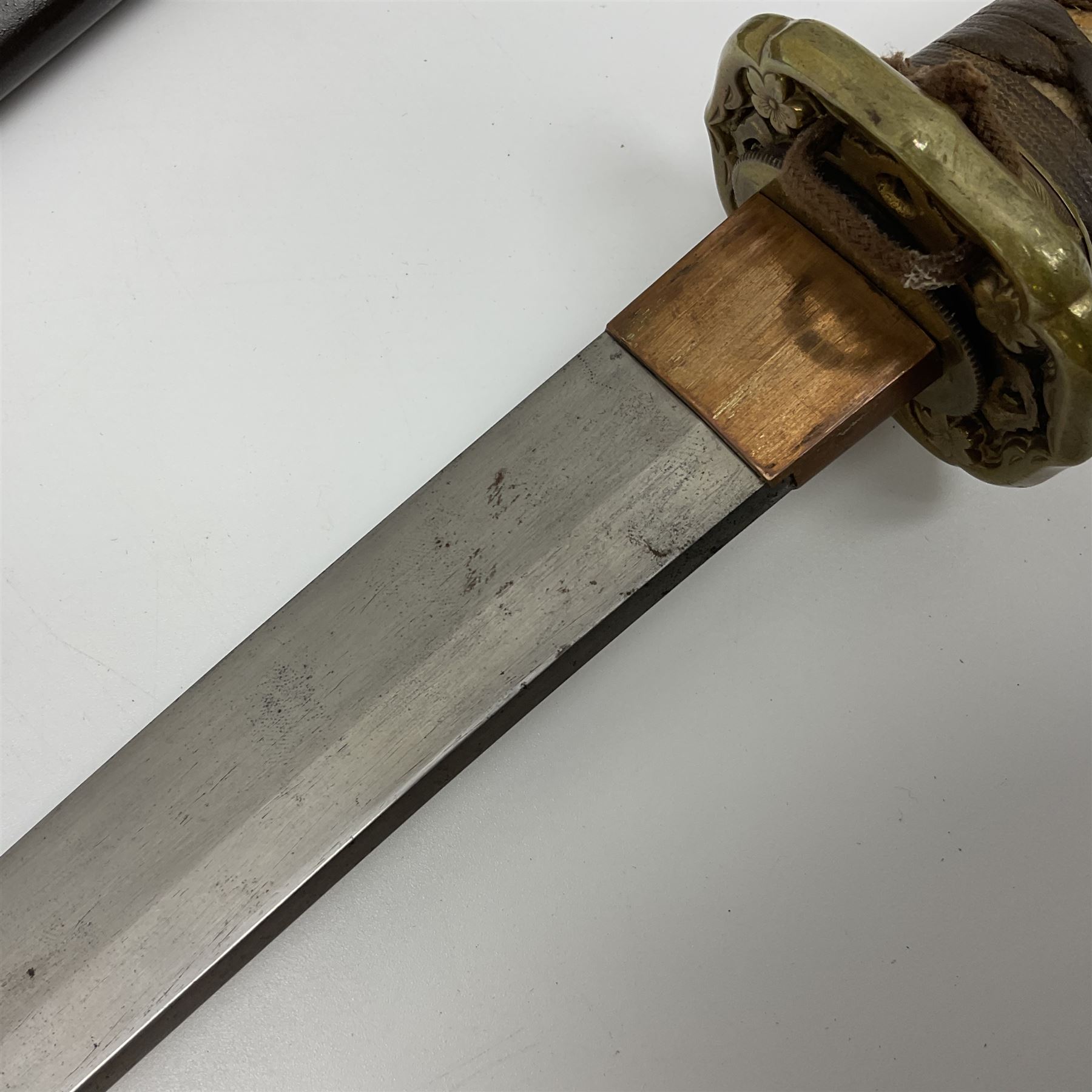WW2 Japanese Army officer's shin gunto/katana sword with 68.5cm steel single edged blade, foliate cast brass tsuba, bound fish-skin grip with brass mounts, inscribed marks to both sides of tang; in lacquered wooden scabbard with brass mounts and locking button L97cm overall