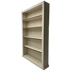 20th century cream painted open bookcase, fitted with four shelves on plinth base