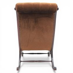 Late 20th century Regency style mahogany framed reading chair, the shaped and moulded frame with scrolled arms and open sides, upholstered in buttoned brown velvet, raised on curved supports terminating in scroll feet