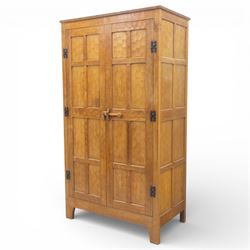Acornman - oak adzed panelled double wardrobe, with wrought iron hinges and carved oak latch revealing a single clothes rail, with signature carved acorn to top left, by the workshop of Alan Grainger, Brandsby