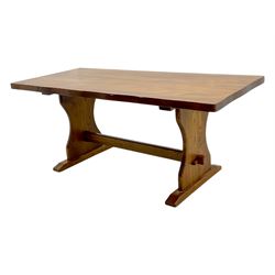 Late 20th century oak trestle table, rectangular top with naturalistic edge, supported by two curved pedestal bases united by central stretcher, on block feet