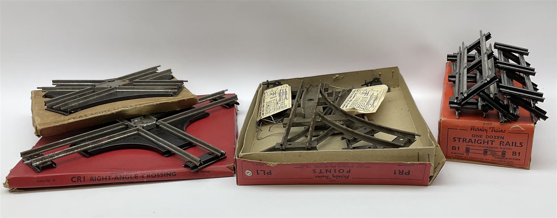 Hornby '0' gauge - layout accessories comprising PR1/PL1 Points, CR1 Right Angle Crossing and CA2 Acute Angle Crossing, all boxed; tin-plate signal box; tin-plate level crossing; textured wooden tunnel, possibly pre-WW2; and quantity of track, some boxed; together with '00' gauge tin-plate station