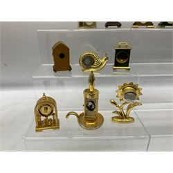 Collection of miniature clocks, predominantly with quartz movements, to include example modelled as an armchair, Edinburgh crystal glass example, clock modelled as a flower, sewing machine etc