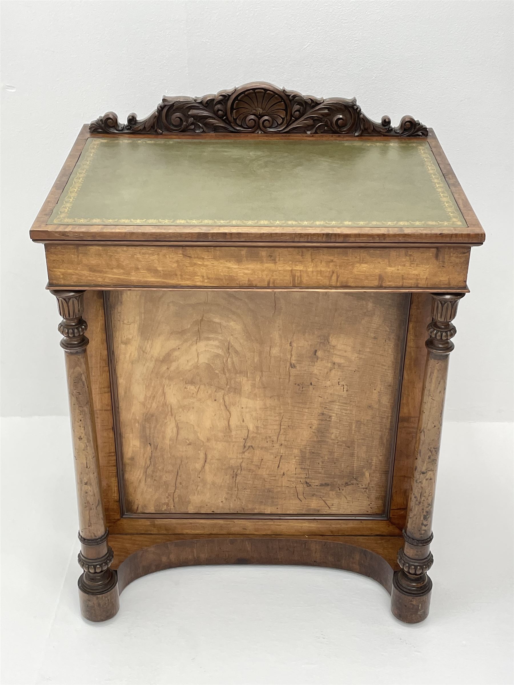 Early Victorian figured mahogany dressing cabinet, the raised shell and scroll carved back lifts to reveal rectangular easel mirror with mahogany band, flat rectangular top with tooled leather inset, slide at each side with matching leather inset, full width drawer above cupboard enclosing a series of five drawers, turned front supports, panelled front, sides and back