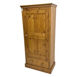 Pine single wardrobe, enclosed by single panelled door, fitted with single drawer, on plinth base 