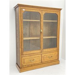 Edwardian oak glazed bookcase with drawer, two glazed doors enclosing two shelves above single long drawer, raised on plinth base 