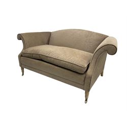 Traditional two seat sofa, curved back over scrolled arms, upholstered in crushed beige fabric with matching loose cushions, on turned front supports with brass and ceramic castors